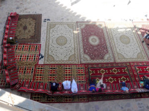 View on people relaxing on nice carpets from top of Nizwa fort in Oman