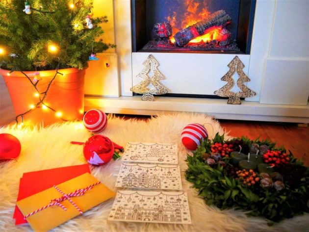 Colouring Christmas cards in front of fireplace