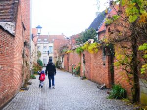 Father and son walking small streets of Mechelen