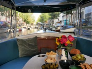 interior of a small boat with Amsterdam canals visible through the windows