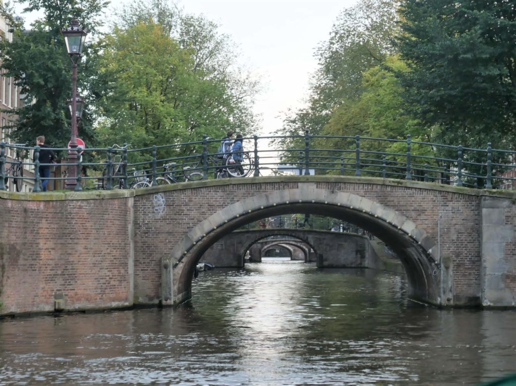 View through the bridges in Amsterdam from a canal
