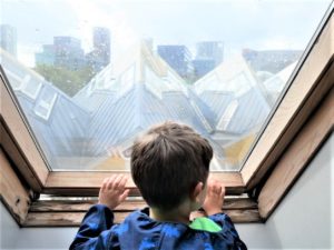 A boy looking through the window of one of the cube houses in Rotterdam