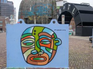 Mural in Amsterdam Noord with a drawing of a head on the blue background