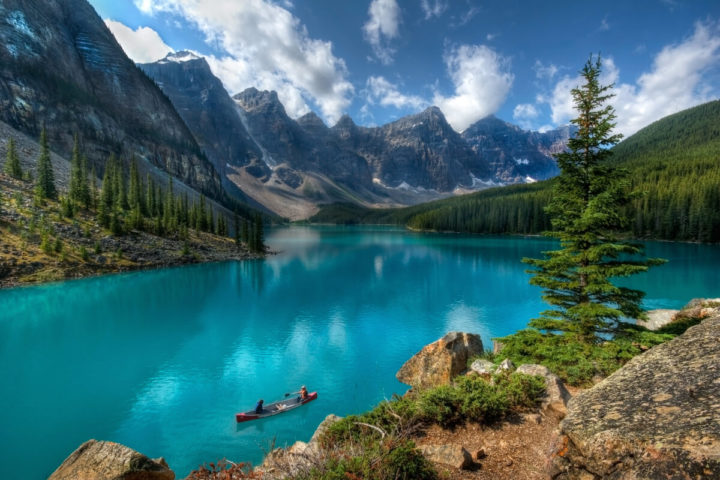 People in a boat at a lake in Canada surrounded by mountains