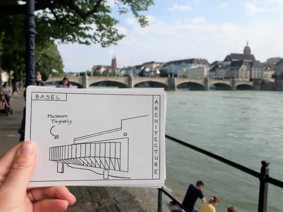 Hand holding the colouring postcard of a Basel