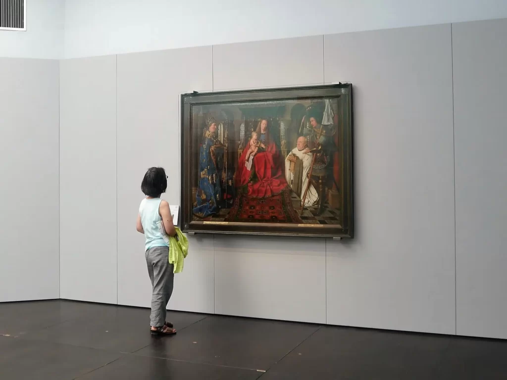 Woman looking at Jan van Eyck's painting in Groeningemuseum Bruges