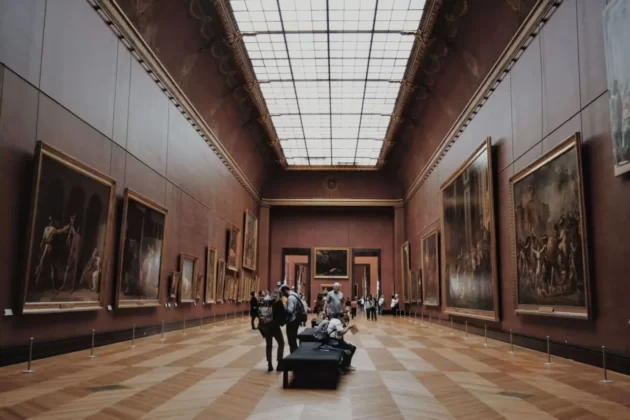 Interior of the museum with people examining paintings